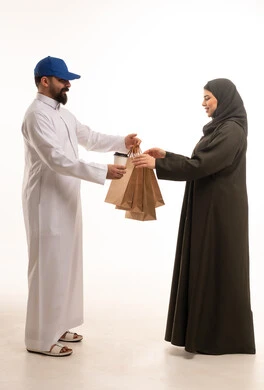 رجل توصيل سعودي يسلم أكياس تسوق لامرأة