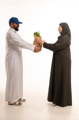 رجل توصيل سعودي يسلم حقيبة بقالة لامرأة