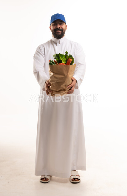 رجل سعودي يحمل كيس ورقي مليء بالخضروات الطازجة