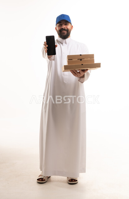 رجل سعودي يحمل علب بيتزا وهاتف ذكي