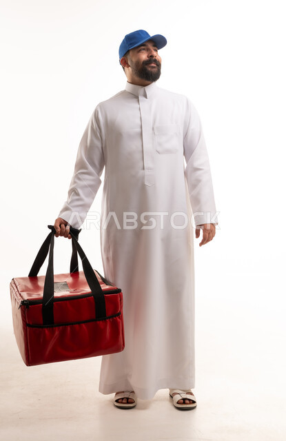رجل توصيل سعودي يحمل حقيبة طعام حرارية حمراء