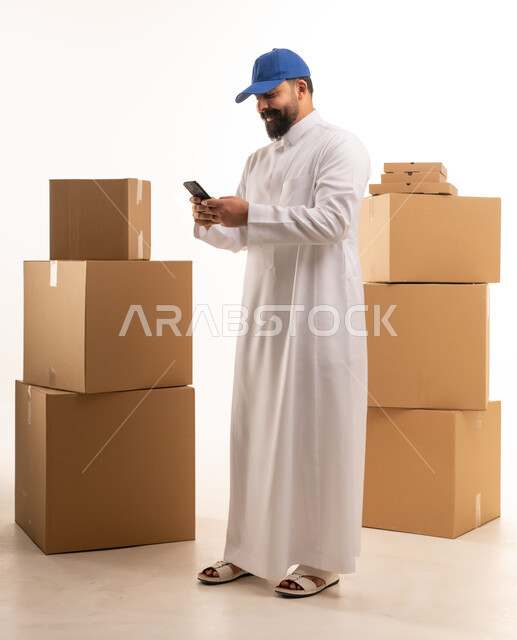 Saudi Man Using Smartphone Beside Shipping Boxes