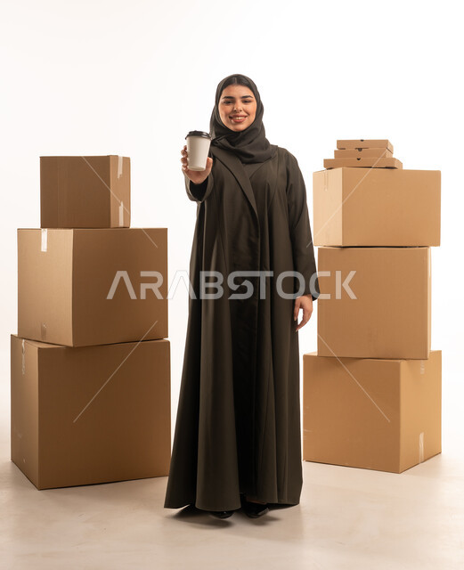 امرأة عربية مع كوب قهوة وصناديق شحن في الاستوديو