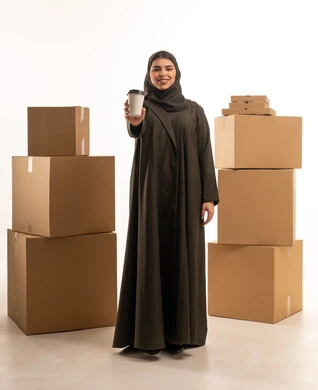 امرأة عربية مع كوب قهوة وصناديق شحن في الاستوديو