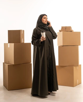 Saudi Woman in Abaya with Moving Boxes and Phone