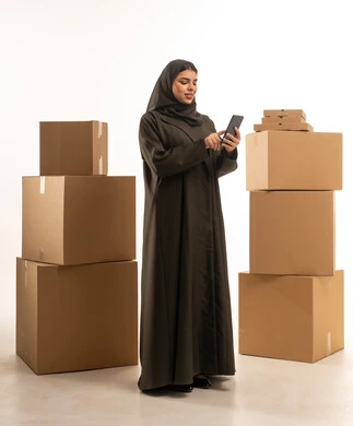 Saudi Businesswoman with Shipping Boxes and Smartphone