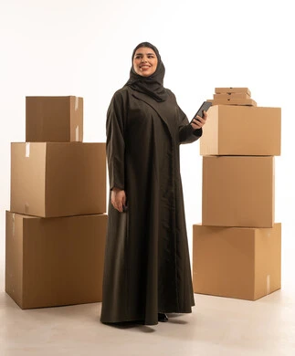 امرأة سعودية مع هاتف ذكي وصناديق شحن