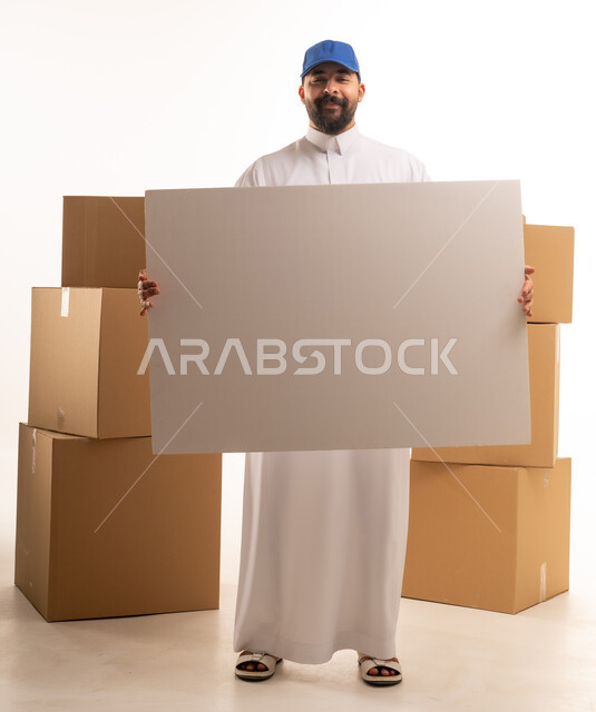 رجل سعودي يحمل لوحة فارغة مع صناديق كرتونية