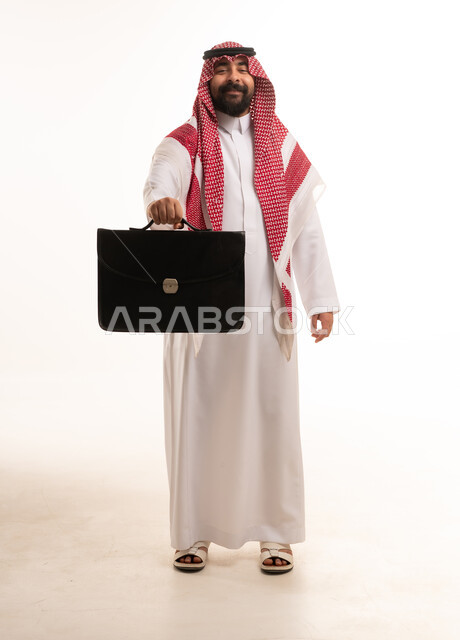 رجل أعمال سعودي يحمل حقيبة عمل على خلفية بيضاء