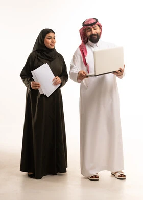 زملاء عمل سعوديون مع كمبيوتر محمول بخلفية بيضاء