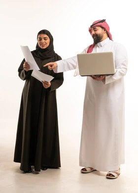 زملاء عمل سعوديون مع جهاز محمول وأوراق عمل