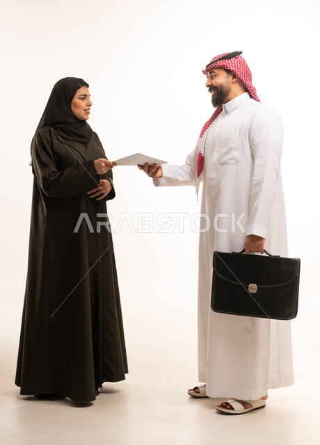 Saudi Business People Handing Over Document in Studio