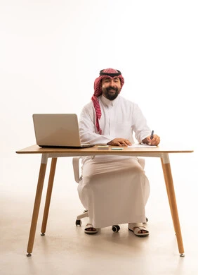 Saudi Businessman Signing Papers at Office Desk