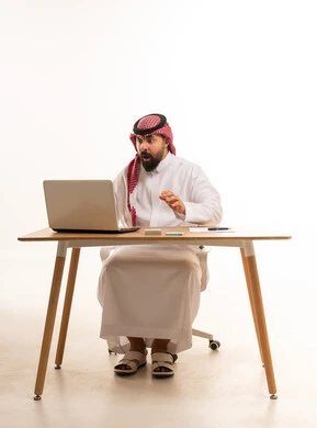 رجل أعمال سعودي متفاجئ أمام المحمول على خلفية بيضاء رجل أعمال سعودي متفاجئ أمام المحمول على خلفية بيضاء