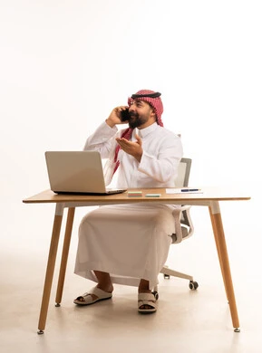 رجل أعمال سعودي يتحدث بالهاتف أمام المحمول
