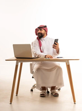 Saudi Man Using Laptop and Smartphone in Studio