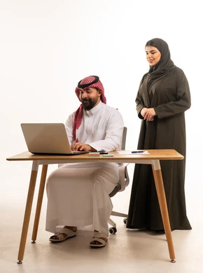 زملاء عمل سعوديين يستخدمون الحاسوب المحمول خلفية بيضاء