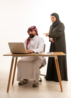 زملاء عمل سعوديون يستخدمون الحاسوب المحمول خلفية بيضاء