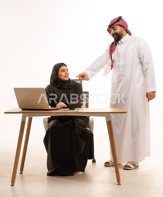 زملاء عمل سعوديين يتناقشون في المكتب أمام الحاسوب