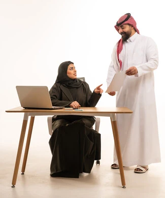 Saudi Business Colleagues Discussing Work at Office Desk