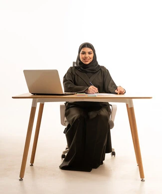 Professional Saudi Woman at Office Desk with Laptop