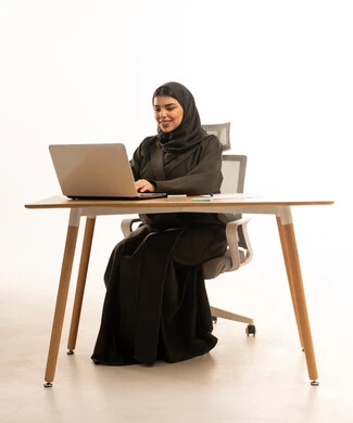 Saudi Woman Working on Laptop at Office Desk