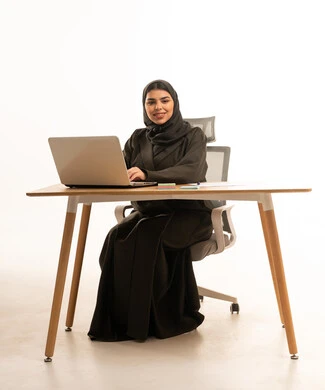 Saudi Woman with Laptop at Office Desk