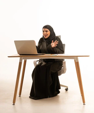 Surprised Saudi Businesswoman with Laptop at Desk
