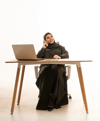 سيدة أعمال سعودية تتحدث بالهاتف في المكتب