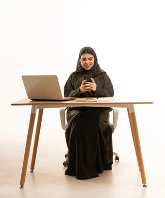Saudi Businesswoman Using Smartphone at Office Desk