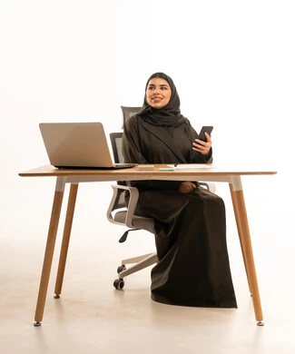 Arab Woman at Office Desk with Laptop and Phone