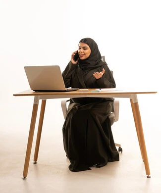 سيدة أعمال إماراتية مع حاسوب محمول وهاتف