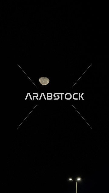 القمر في السماء الليلية فوق الواجهة البحرية بالدمام