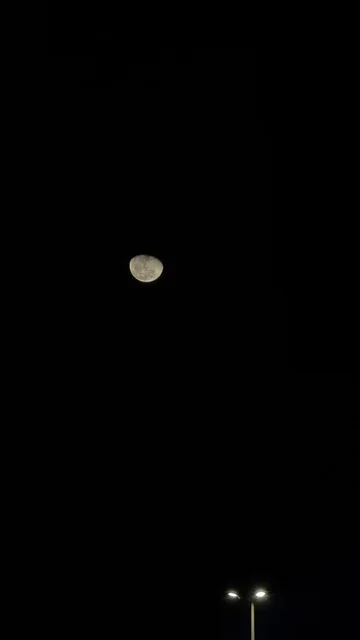 القمر في السماء الليلية فوق الواجهة البحرية بالدمام