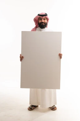 رجل سعودي بالزي التقليدي يحمل لوحة بيضاء فارغة
