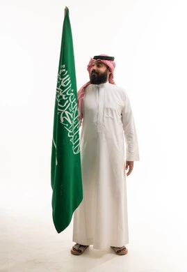 Saudi Man Holding Saudi Arabian Flag in Studio