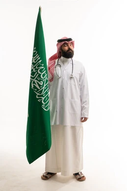 Saudi Male Doctor Holding Saudi Flag in White Studio