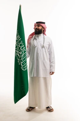 طبيب سعودي بالزي الرسمي مع العلم الوطني