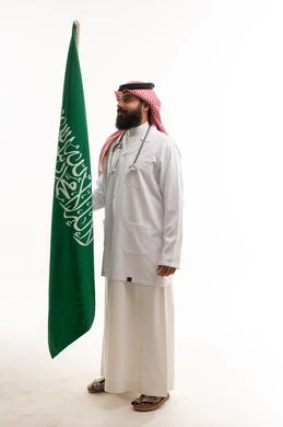 طبيب سعودي مع علم المملكة العربية السعودية