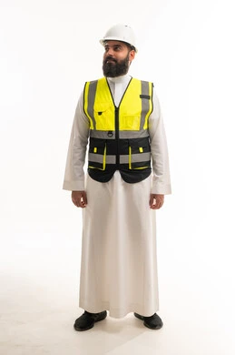 مهندس سعودي بالثوب والزي الواقي بخلفية بيضاء