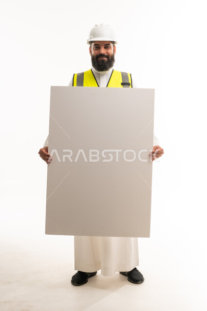مهندس سعودي بالثوب يحمل لوحة إعلانية فارغة