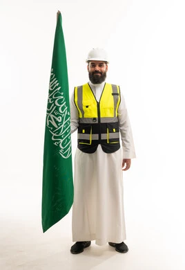 مهندس سعودي بملابس السلامة يحمل علم المملكة العربية السعودية