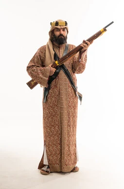 رجل سعودي بالزي الشعبي يحمل بندقية قديمة