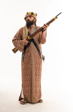 رجل سعودي بالزي التراثي التقليدي يحمل بندقية