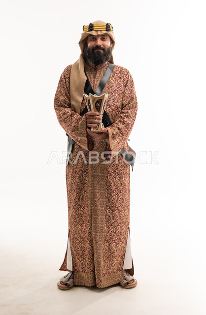 رجل سعودي بالزي التقليدي يمسك مبخرة تراثية