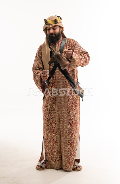 رجل سعودي بالزي التقليدي يصب القهوة العربية
