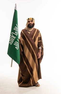 Saudi Man in Traditional Bisht Holding National Flag