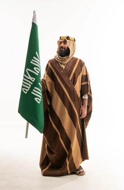 Saudi Man with National Flag in Traditional Bisht