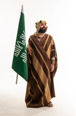 Saudi Man Holding Kingdom Flag in Traditional Farwa