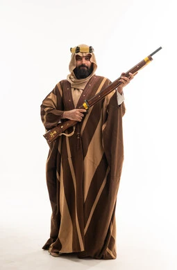 رجل سعودي بالزي التقليدي يحمل بندقية كلاسيكية